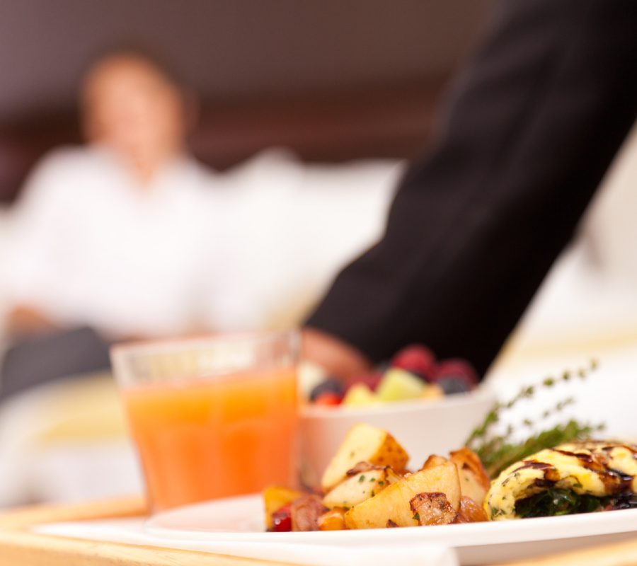 Room service setting down a nice breakfast for hotel guest.