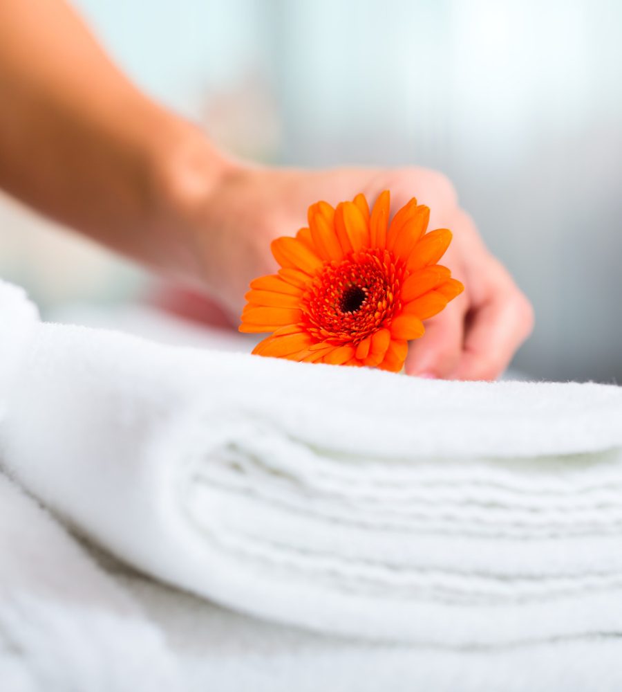 Maid doing room service in hotel, she is making up the beds